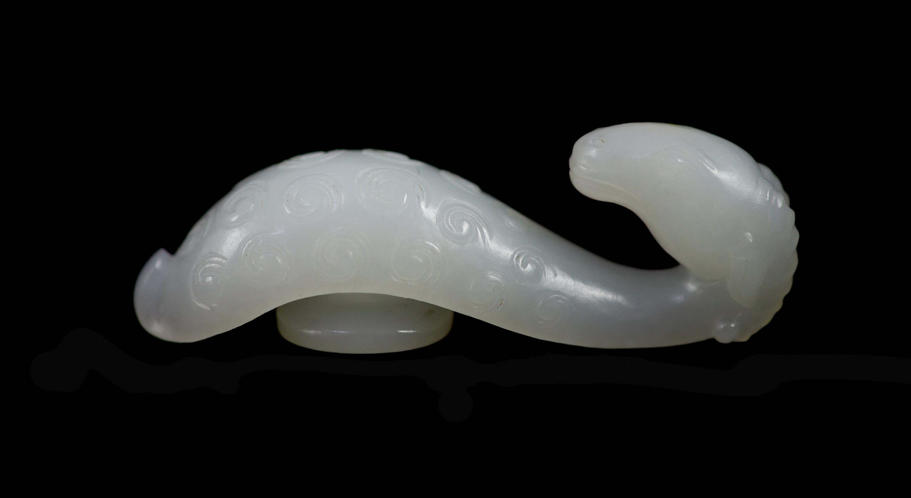 A Chinese white jade 'ram’s head’ belt hook, 6.4 cm long